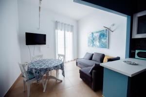 ein Wohnzimmer mit einem Sofa und einem Tisch in der Unterkunft "LUMINARIA" casa nuova in Salento fronte mare!!! in Sant'Isidoro