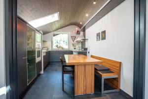 a kitchen and dining room with a wooden table and chairs at Tubris Living in Sand in Taufers