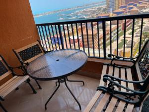 a table and chairs on a balcony with a view of the ocean at sea view apartment in Porto Marina in El Alamein