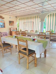 a dining room filled with tables and chairs at Calou Guest House in La Digue