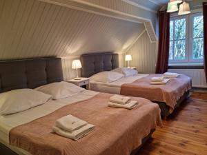 two beds in a room with towels on them at Mistral przy plaży Domki całoroczne in Ustka