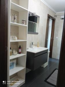 ein Badezimmer mit Waschbecken und Spiegel in der Unterkunft Casa Xesteira Cambados in Cambados