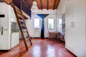 une cuisine et une salle à manger avec un escalier et une table dans l'établissement Mansardina Nosadella 8 by Wonderful Italy, à Bologne