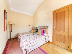 a bedroom with two beds and a wooden door at Belvilla by OYO Holiday home in Jand a in Morro del Jable