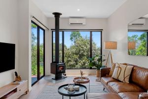 a living room with a couch and a stove at The Ridge at Maleny 1 Bedroom Villa with Spa in Maleny