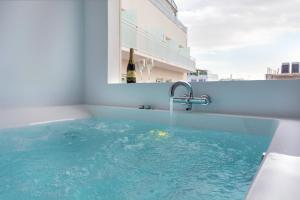 a bath tub with a bottle of wine in it at Dema Luxury Suites - Perikleous E8 in Athens