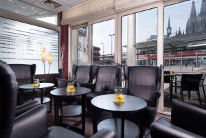a restaurant with tables and chairs and a view of the city at Wyndham Köln in Cologne