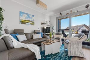 uma sala de estar com um sofá e cadeiras e uma grande janela em Ostsee - Appartement Nr 162 "Strandzeit" im Strand Resort em Heiligenhafen