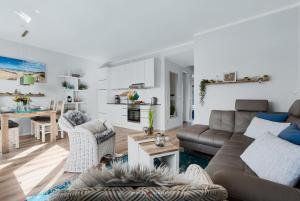uma sala de estar com um sofá e uma mesa em Ostsee - Appartement Nr 162 "Strandzeit" im Strand Resort em Heiligenhafen