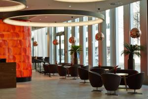 a lobby with chairs and tables in a building at H4 Hotel München Messe in Munich