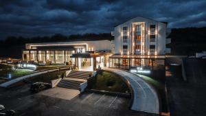 锡盖图马尔马切伊Iza Hotel的一座晚上有灯的建筑