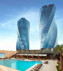 deux grands bâtiments en verre avec une piscine à l'avant dans l'établissement Burgu Arjaan by Rotana Istanbul Asia, à Istanbul