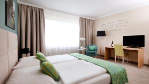 
a bedroom with a bed, chair and a television at Henriette Stadthotel ex Das Capri in Vienna
