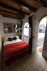 une chambre avec un lit et une porte ouverte dans l'établissement Dar Farah, riad au coeur de la médina, à Essaouira