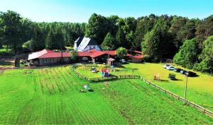 una vista aérea de un gran campo verde con un granero en Gospodarstwo Agroturystyczne Andrzejówka, en Gardzień