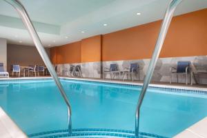 una piscina en una habitación de hotel con sillas y mesas en La Quinta Inn & Suites by Wyndham Marysville, en Marysville