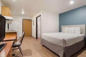 Tempat tidur dalam kamar di WoodSpring Suites Houston I-45 Airtex