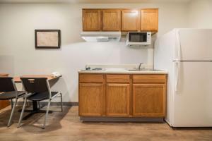 uma cozinha com um frigorífico, uma mesa e cadeiras em WoodSpring Suites Houston La Porte em La Porte