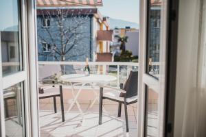 una mesa blanca y sillas en un balcón con ventana en Ascona: Residenza Principessa Apt. 9, en Ascona