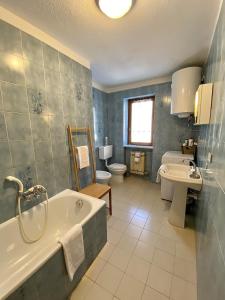 a bathroom with a tub and a toilet and a sink at La Maison De Chouflette in Cogne