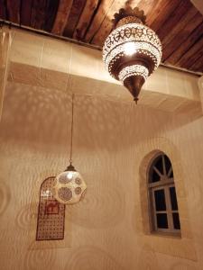 - deux lustres suspendus au plafond dans une pièce dans l'établissement Dar Farah, riad au coeur de la médina, à Essaouira