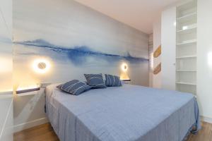 a bedroom with a blue bed with two pillows at NEVERENDING RIJANA. ¡Cala Rijana a tu alcance! in Calahonda