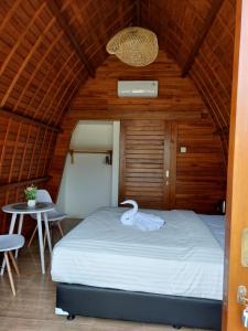 a bedroom with a bed with a swan on it at Les chalets Uluwatu in Uluwatu