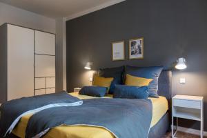 1 dormitorio con 1 cama con almohadas azules y amarillas en fewo1846 - flensBURG - komfortable Maisonettewohnung für 6 Personen mit Dachbalkon im 4 OG, en Flensburg