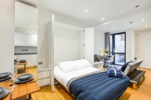 a bedroom with a large bed and a kitchen at Spacious Studio Apartment with private patio near Warren Street in London