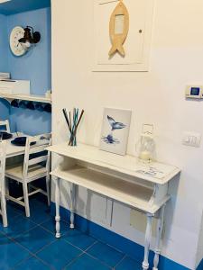 białe biurko w pokoju ze stołem i krzesłami w obiekcie Sun&SeaGuestHouse Lido di Roma w mieście Lido di Ostia