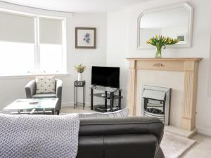 a living room with a couch and a fireplace at The Toll House in Melrose