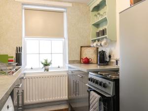 uma cozinha com uma janela e um fogão em The Toll House em Melrose