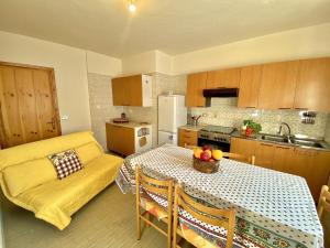 a kitchen with a table and a yellow couch at La Maison De Chouflette in Cogne +37 photos