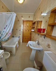 a bathroom with a sink and a tub and a toilet at La Maison De Chouflette in Cogne