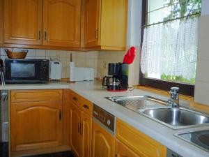 a kitchen with a sink and a microwave at Holiday home in Saxony with private terrace in Schlettau