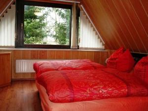 a large red bed in a room with a window at Holiday home in Saxony with private terrace in Schlettau
