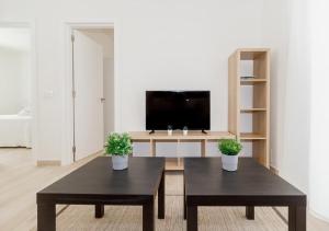 sala de estar con 2 mesas y TV en Moderno apartamento urbano en barrio histórico 1ºD, en Santa Cruz de Tenerife
