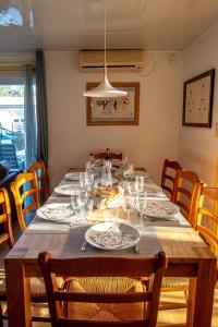 - une table à manger avec des assiettes et des verres dans l'établissement Mettez vous au vert au cœur de la Charente maritime, à Saint-Germain-de-Marencennes