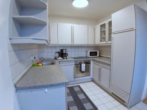 a kitchen with white cabinets and a white refrigerator at LEA-Apartment, 2 Raum, Balkon TG zentral am Park in Leipzig