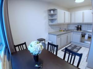 a kitchen with a table with a vase of flowers on it at LEA-Apartment, 2 Raum, Balkon TG zentral am Park in Leipzig