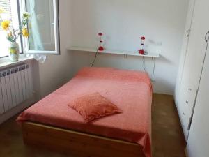 モネーリアにあるBelvilla by OYO Pizzamiglioの小さなベッドルーム(赤いシーツと窓付きのベッド付)