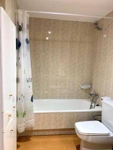 a bathroom with a white tub and a toilet at Apartamento Centrico con Parking in Rialp