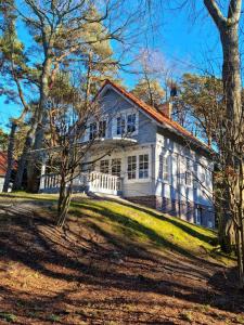 una casa bianca con degli alberi di fronte di Mistral przy plaży Domki całoroczne a Ustka