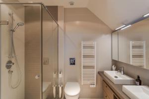 a bathroom with a shower and a toilet and a sink at Résidence Premium Le Bénétin- Saint Malo in Saint Malo +72 photos