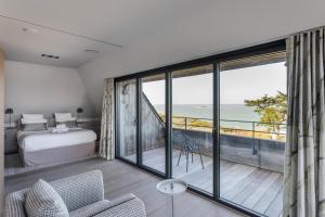 um quarto com uma cama e vista para o oceano em Résidence Premium Le Bénétin- Saint Malo em Saint Malo