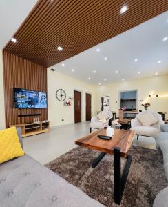 uma sala de estar com um sofá e uma mesa em Luxury 3BR Villa w Plunge Pool near SM Batangas City- Instagram-Worthy! em Batangas City