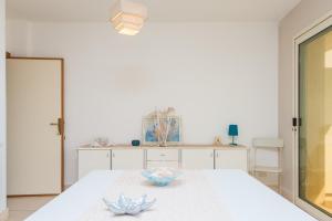 Una habitación blanca con una mesa con dos tazones. en Beach Studios con accesso diretto alla spiaggia, en Torre Pali