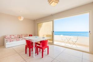 comedor con mesa y sillas y vistas al océano en Beach Studios con accesso diretto alla spiaggia, en Torre Pali