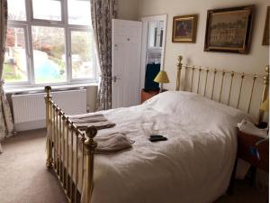 a bedroom with a white bed with a large window at Residential 3 bed house Harnham in Salisbury
