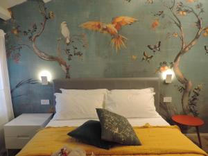 a bedroom with a bed with birds on the wall at Al Sagraeto in Chioggia
